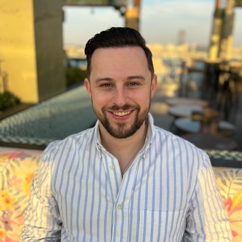 Aidan Godfrey, founder of Techgeezer, smiling on a rooftop terrace