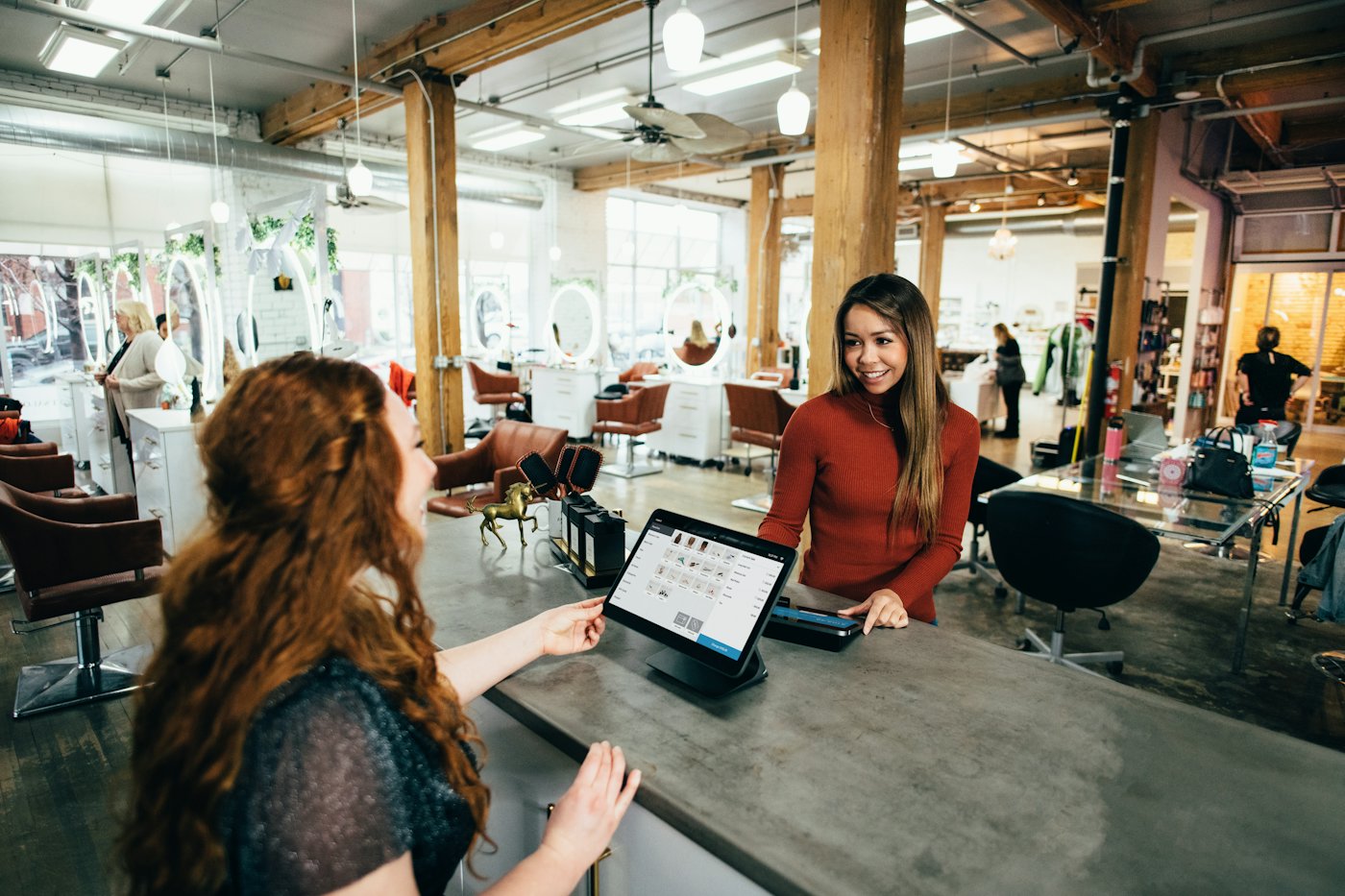 A business owner at a reception desk with a laptop