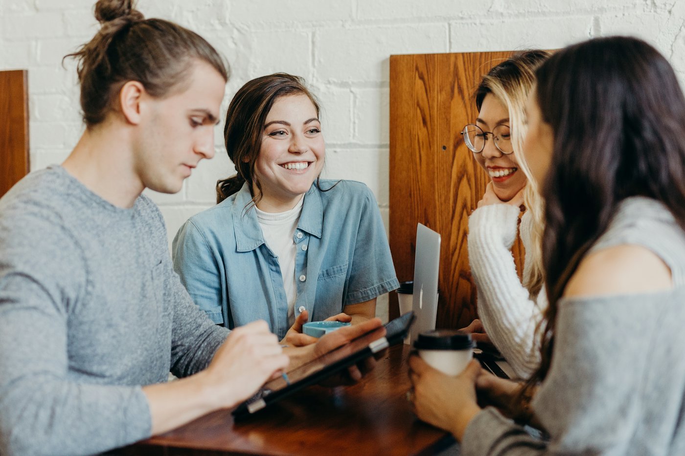 A small team gathered around one laptop, smiling